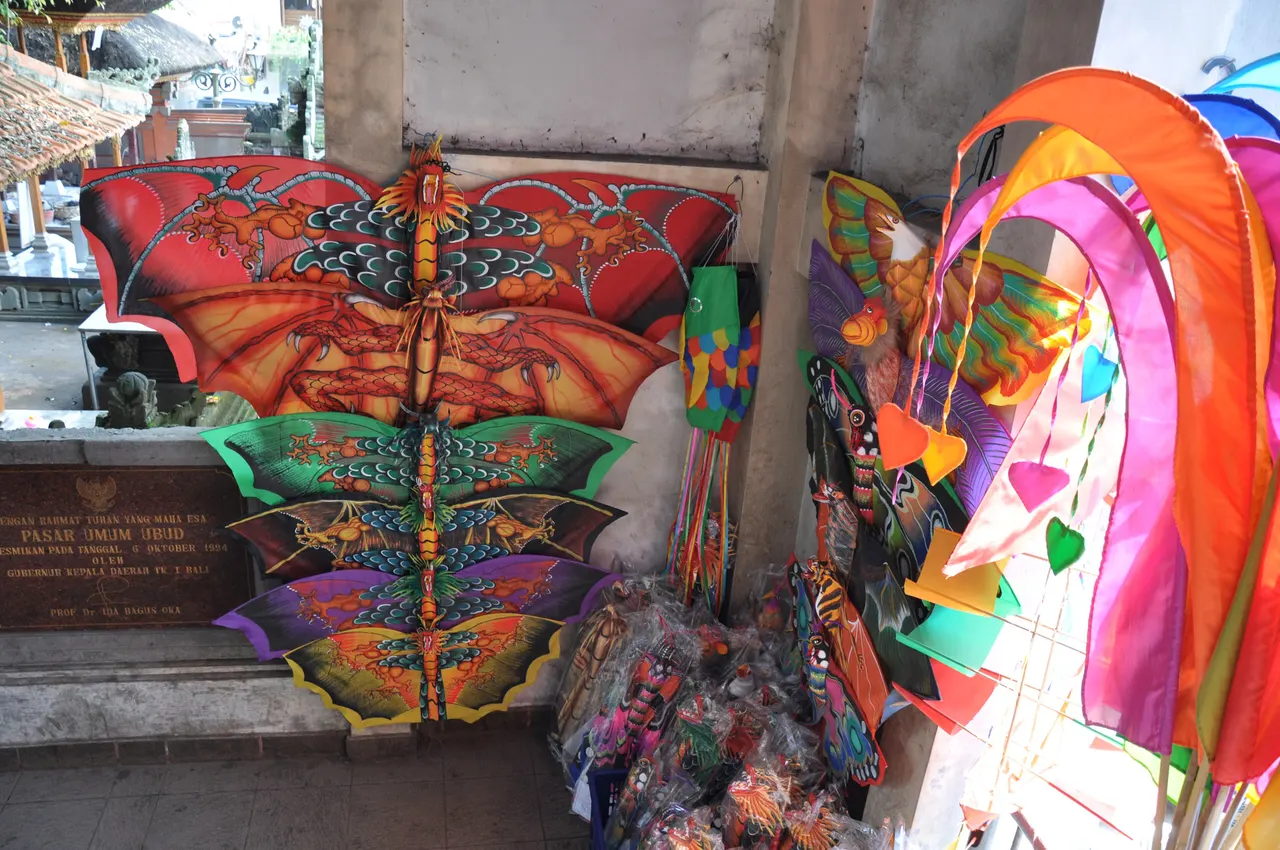 Handicraft stall at Ubud market, Bali, hung with painted butterfly kites, carved masks and colourful windsocks.
