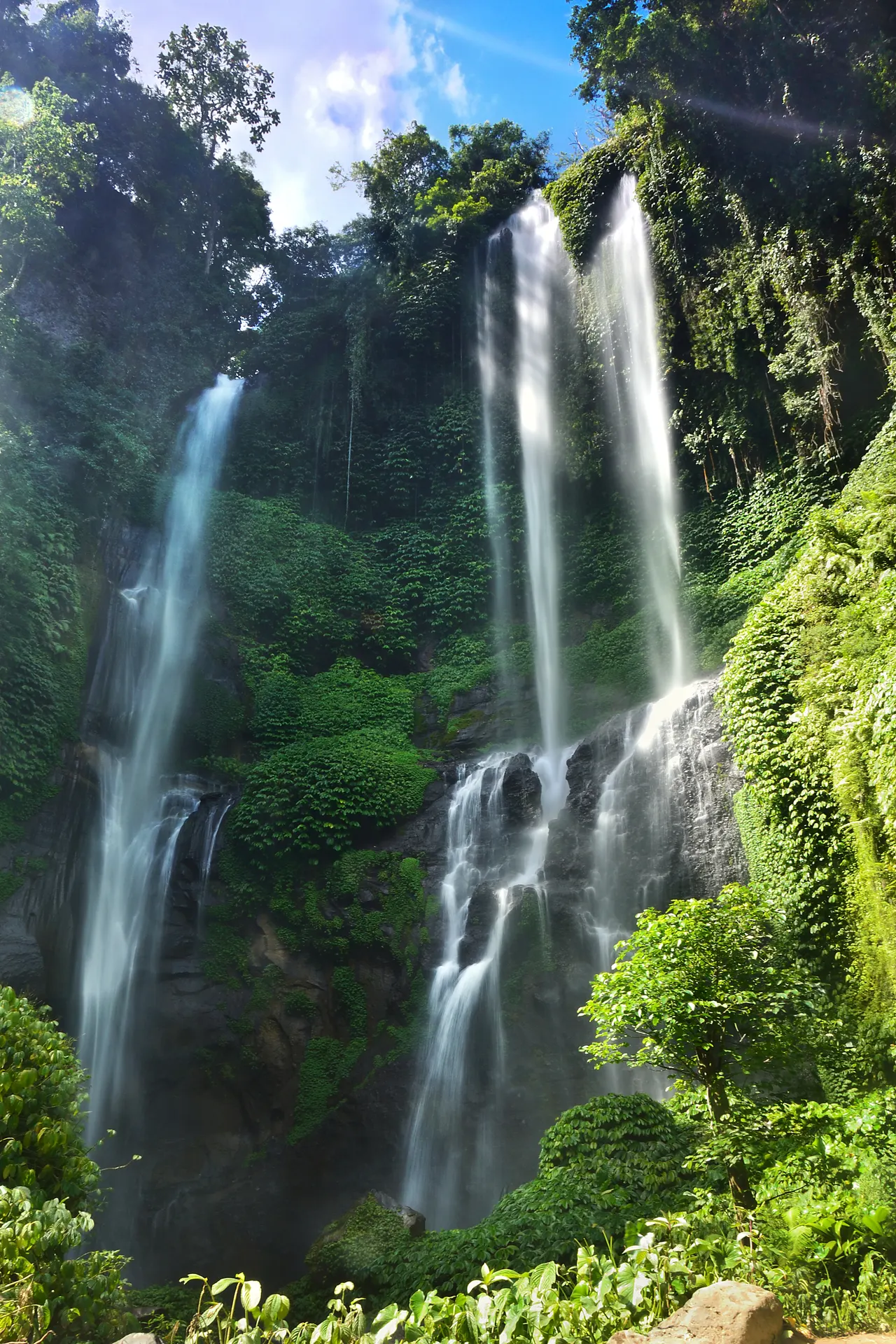 The multi-strand Sekumpul waterfall falling down a jungle-covered cliff in Buleleng, north Bali.